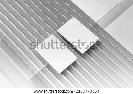 Branding envelope mockup template, with sharp natural shadows and reeded glass, real photo. Blank isolated on a white background to place your design. 