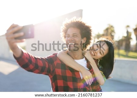  Beautiful young couple in love walking at the city street. Happy couple taking selfie photo