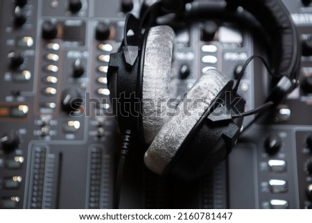 Professional dj headphones on sound mixer. High quality disc jockey head monitors. Curated collection of royalty free images of audio equipment for DJs and musicians. Download party poster template
