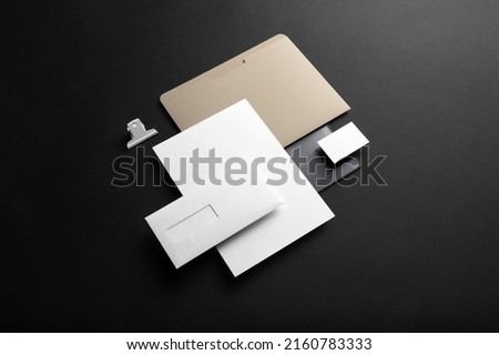 Black branding stationery mockup template, real photo, includes folder, notebook, business card, envelope. Blank isolated on a black background to place your design