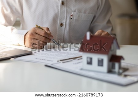 Businessman in casual clothes signing a real estate deal contract.