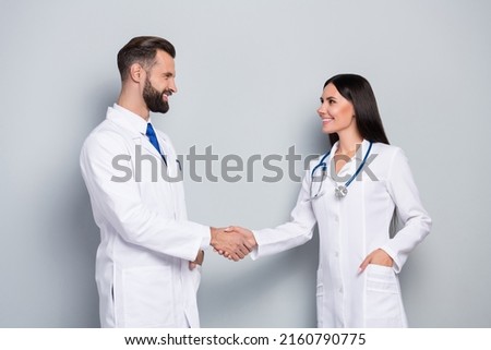 Portrait of two attractive successful cheery medics shaking hands support career isolated on grey color pastel background Royalty-Free Stock Photo #2160790775
