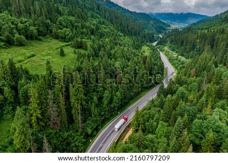 convoys with cargo. trucks on the higthway. cargo delivery driving on asphalt road through the mountains. seen from the air. Aerial view landscape. drone photography. 