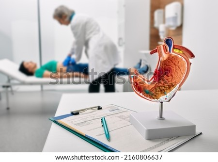 Gastroenterologist consultation, treatment of stomach diseases and ulcers. Doctor palpates woman patient abdomen and examines belly at clinic Royalty-Free Stock Photo #2160806637