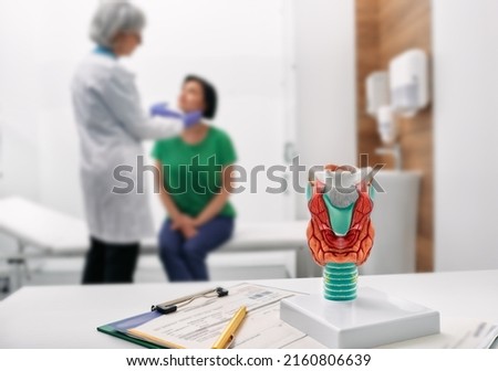 Doctor palpates of woman's neck for diagnostics of thyroid diseases. Thyroid gland exam and treatment Royalty-Free Stock Photo #2160806639