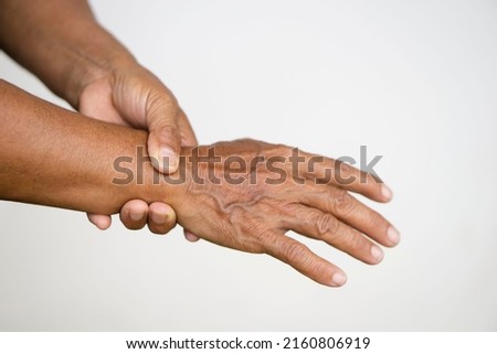 Closeup elderly hands  massage painful wrist. Concept : health problem. Senior healthcare.  Massage for relieve of  hurt or painful. Wrist symptomatic. Royalty-Free Stock Photo #2160806919