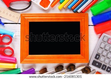 Framework and school tools around. On a white, wooden background.