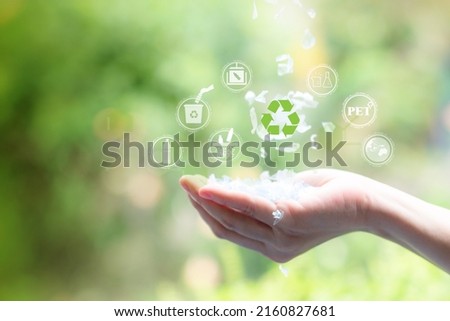 Plastic flakes sprinkled on hands. and has a green blur background. Recycle icon, sustainable icon and Bottle icon. Chemical concept