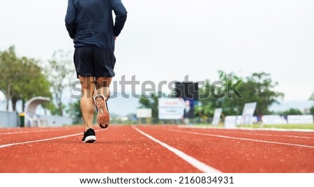 Close up legs Young chinese man wearing sportswear running on track at sport stadium. Fit man jogging outdoor cross the finish line. Exercise in the morning. Healthy and active lifestyle concept. Royalty-Free Stock Photo #2160834931