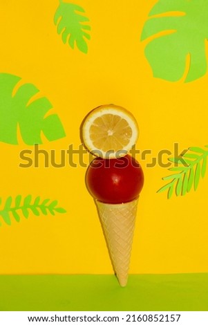 slice lemon and tomato in ice cream zone on a yellow background with tropical jungle leaves, creative summer design, vocations time, health ice cream