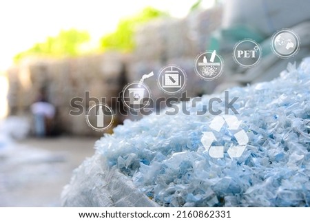 PET plastic bottle flakes in white big bag with blur plastic bottle bales background. Recycle icon, sustainable icon and Bottle icon. Chemical concept