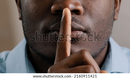 Mysterious unknown male face part african american adult man put finger to lips ask be quiet make gesture silence show secrecy sign keep secret confident information silent forbid tell close up view Royalty-Free Stock Photo #2160911421