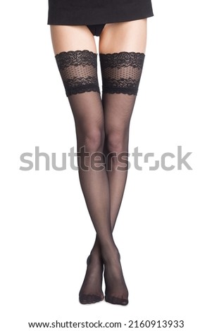 Beauty woman legs in black lace stockings. Part body of woman. Slim attractive gorgeous female legs in black lace stockings standing on tiptoe isolated on white.