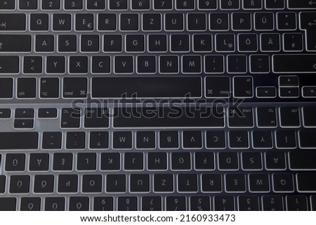 Wireless aluminum keyboard on the black table from above.