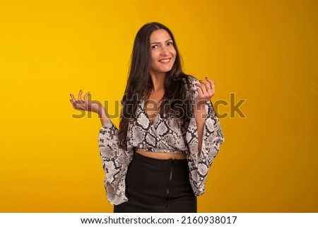 Young woman wearing formal wear and eyeglasses in studio photo with yellow background