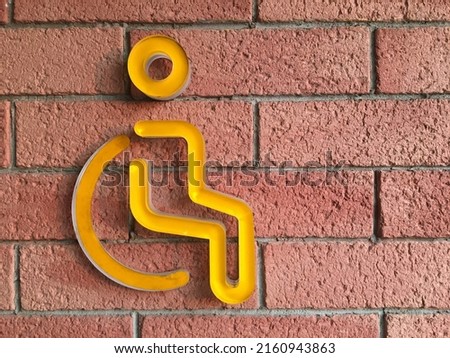 sign for disability on a red brick wall