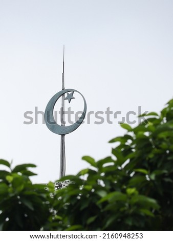 crescent moon and star mosque symbol on green leaf background