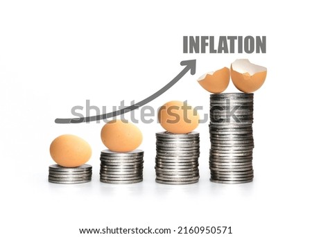 Soaring egg prices and the effects of inflation. Food prices rising. Economic crisis. High expense cost of consumer. Coins stacks with broken egg. Royalty-Free Stock Photo #2160950571