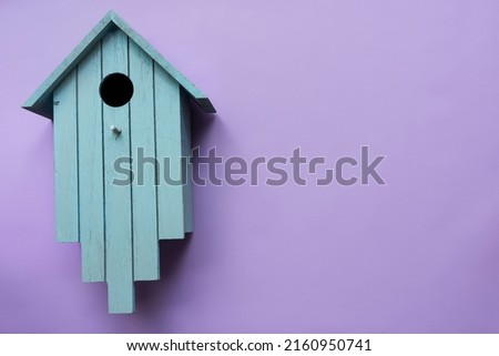 Birdhouse on a lilac background. View from above.
