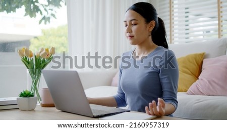Workforce break time deep breath close eyes comfy workspace sit smile easy on floor relax enjoy yoga at cozy sofa couch help boost power energy in work at home office for asia people young teen girl. Royalty-Free Stock Photo #2160957319