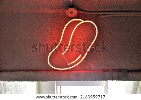 red tongue-shaped neon sign on the wall
