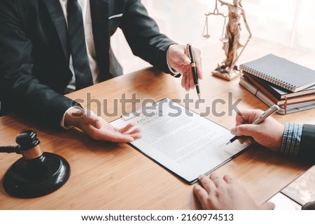 Portrait of a lawyer signing documents in a courtroom.