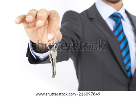 Businessman with a house key in hand isolated on white