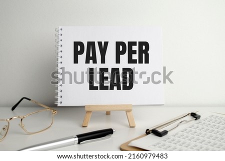 PAY PER LEAD text on white paper and glasses