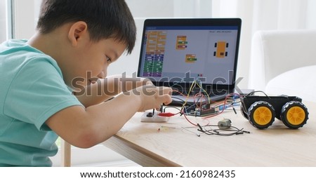 Asia home school young small kid happy smile self study online lesson excited make AI circuit toy. STEM STEAM digital scratch class on laptop screen for active children play arduino enjoy fun hobby. Royalty-Free Stock Photo #2160982435