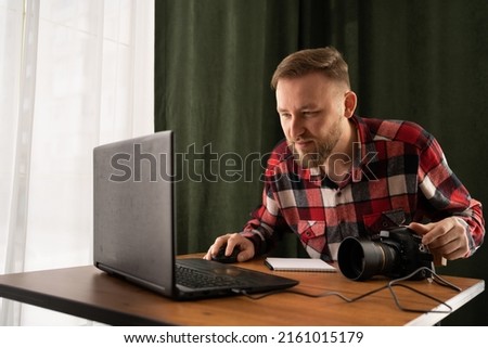 Photographer off loading files on laptop. Checking photos working at modern office. editing his images on laptop. copy space