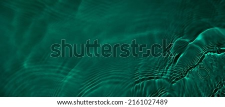 Transparent dark green clear water surface texture with ripples and splashes. Abstract summer banner background Water waves with copy space, top view. Cosmetic moisturizer micellar toner emulsion Royalty-Free Stock Photo #2161027489