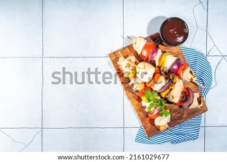 Chicken and vegetable kebabs on wooden skewers, healthy balanced diet bar-b-q party recipe, dark grey concrete background copy space top view
