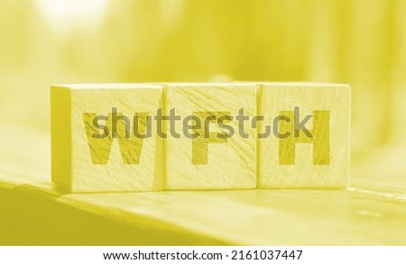 Wooden blocks with letters WFH. Work From Home. Nature background. selective focus. new business concept.