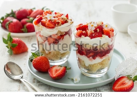delicious strawberry vanilla cream dessert in glasses served with fresh berries, white background Royalty-Free Stock Photo #2161072251