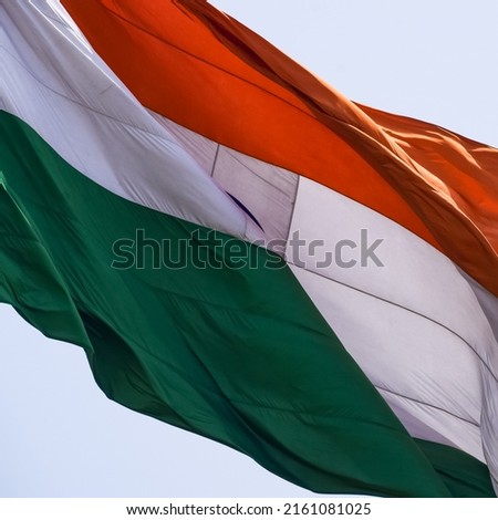 India flag flying high at Connaught Place with pride in blue sky, India flag fluttering, Indian Flag on Independence Day and Republic Day of India, tilt up shot, waving Indian flag, Flying India flags