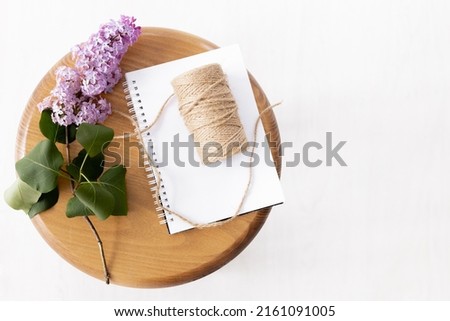Clean notepad with spring lilac flowers on brown wooden background