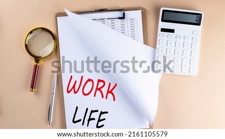 Clipboard with chart and text WORK LIFE with magnifier ,calculator on a beige background