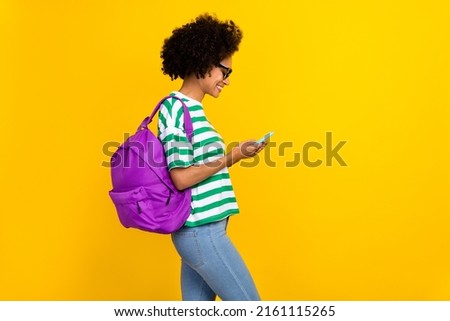 Profile photo of nice millennial brunette lady hold telephone wear eyewear t-shirt jeans bag isolated on yellow background