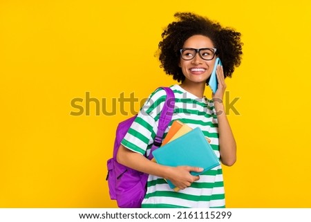 Photo of funny young brunette lady say telephone hold book look promo wear glasses t-shirt bag isolated on yellow background