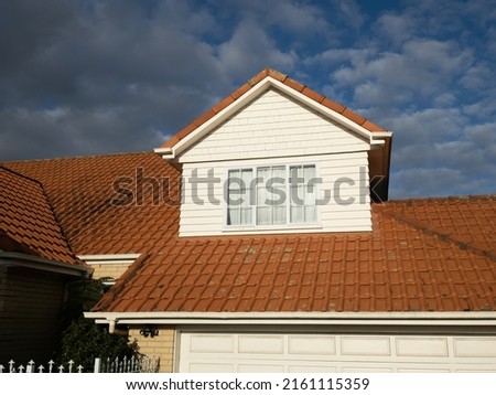 View of pitched roof dormer loft with window and concrete tiles