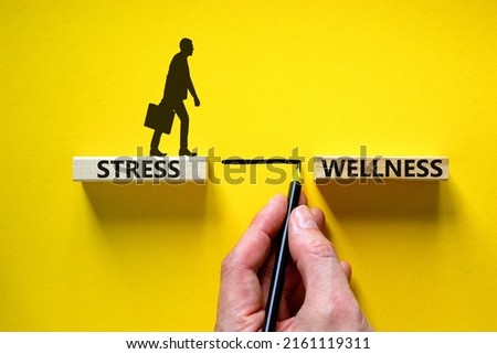 Stress or wellness symbol. Wooden blocks with words 'Stress, wellness'. Yellow background. Businessman hand, businessman icon. Psychological, business and stress or wellness concept. Copy space. Royalty-Free Stock Photo #2161119311