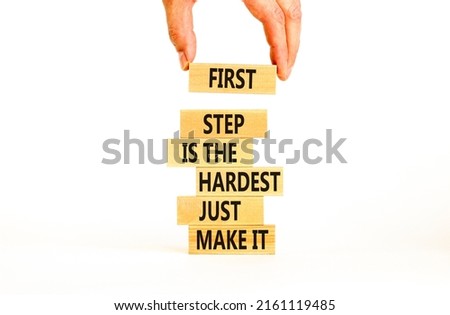 Make first step symbol. Wooden blocks with words First step is the hardest just make it. Beautiful white table white background. Businessman hand. Business and make first step concept. Copy space.