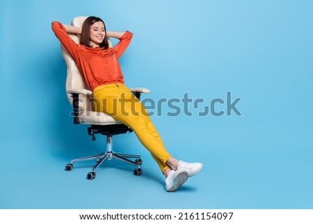 Full length body size view of attractive cheerful dreamy girl resting in office armchair isolated over bright blue color background Royalty-Free Stock Photo #2161154097