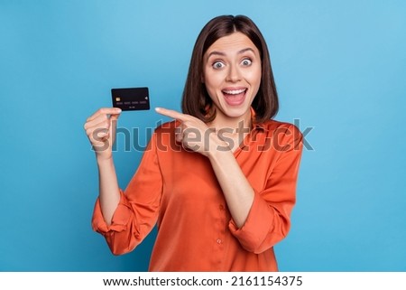 Portrait of attractive crazy cheerful girl demonstrating bank card freelance currency isolated over bright blue color background