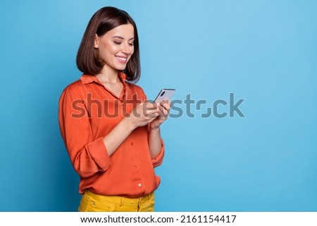 Portrait of attractive cheerful focused girl using device copy space ad advert isolated over bright blue color background