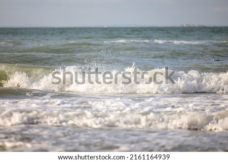 Crashing waves lapping on the sandy beach one after another under a blue sunset sky, selective focus used. High quality photo
