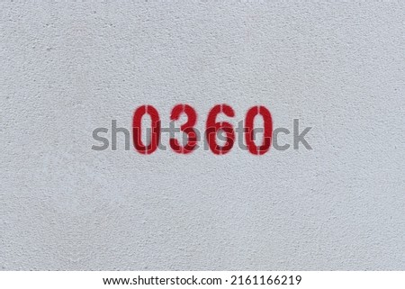 Red Number 0360 on the white wall. Spray paint.
