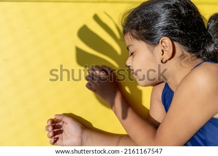 Little girl with a swimsuit is receiving the sun with direct light.