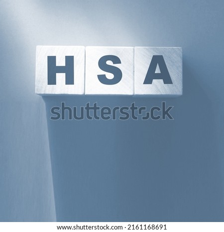 HSA abbreviation is written on wooden cubes on red backgrond. Concept. Health Savings Account.