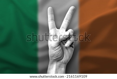 Hand making the V victory sign with flag of ireland